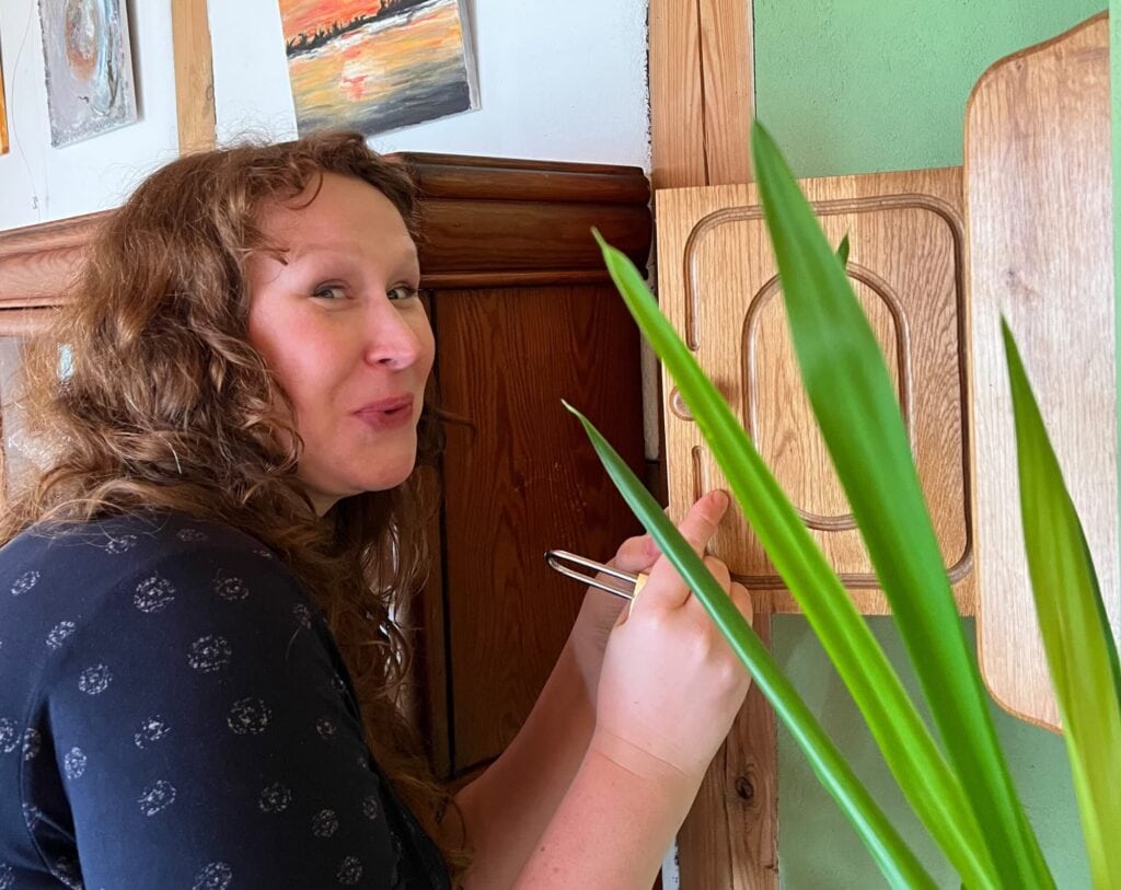 Claudia öffnet einen Schrank an der Wand