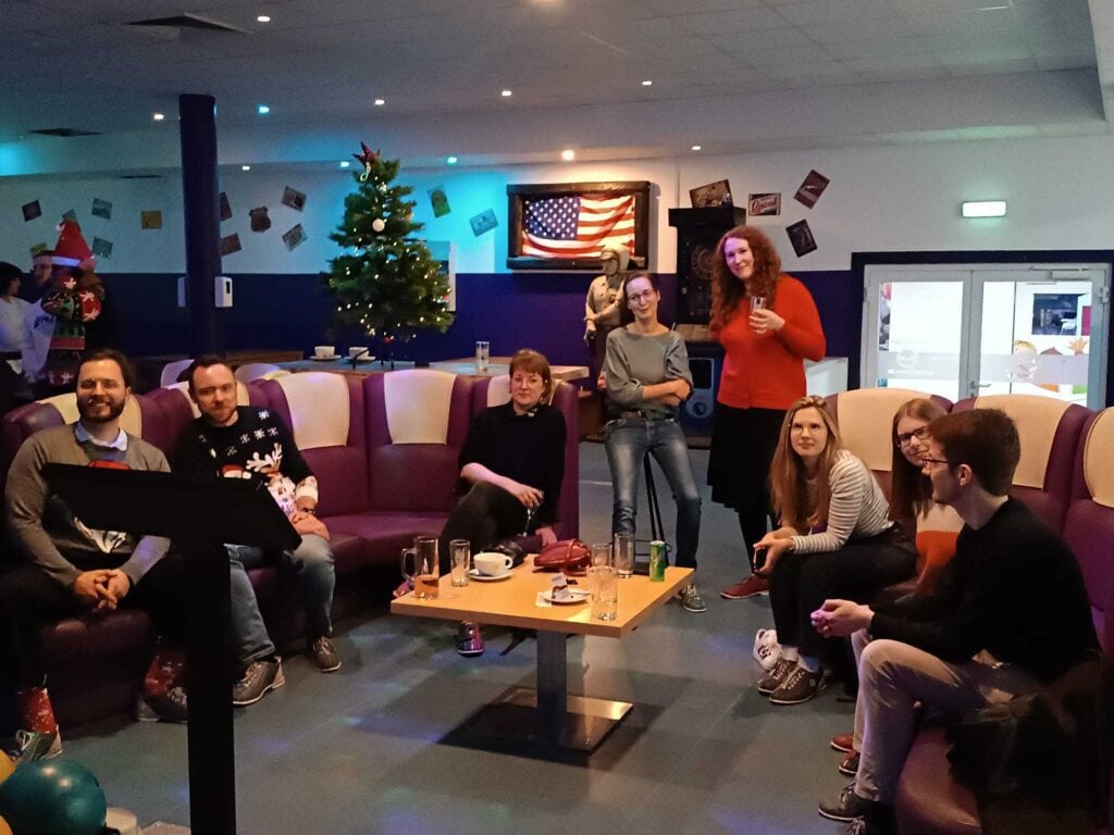 Hupa-Team sitzt am Tisch vor der Bowlingbahn