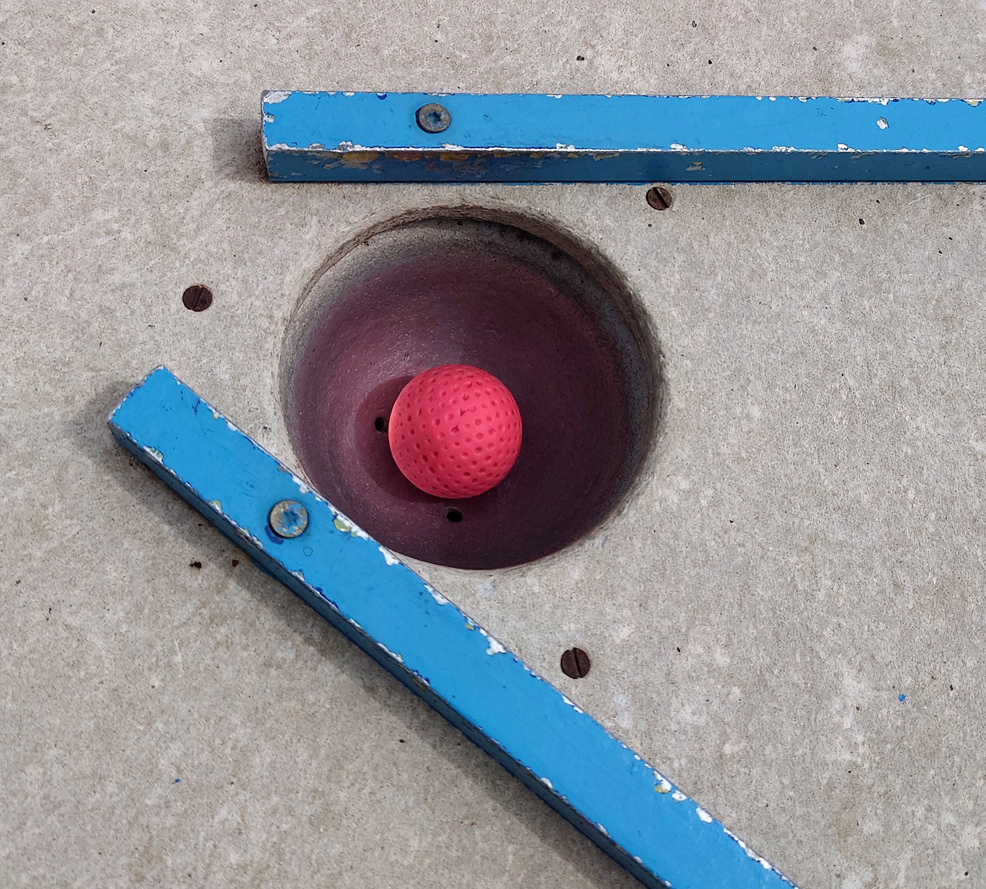 Hupa Teamevent Minigolf 4 Nahaufnahme von dem Minigolfball im Zielloch einer Golfbahn.