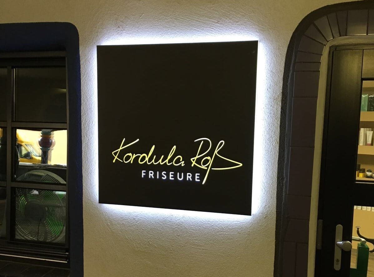 Designte Leuchtreklame für Kordula Roß Friseure hängt an der Wand