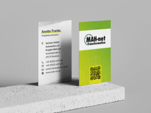 Gesatltung von Visitenkarten: Die Visitenkarten von MAH-net Magdeburg stehen aufrecht auf einem Tisch.