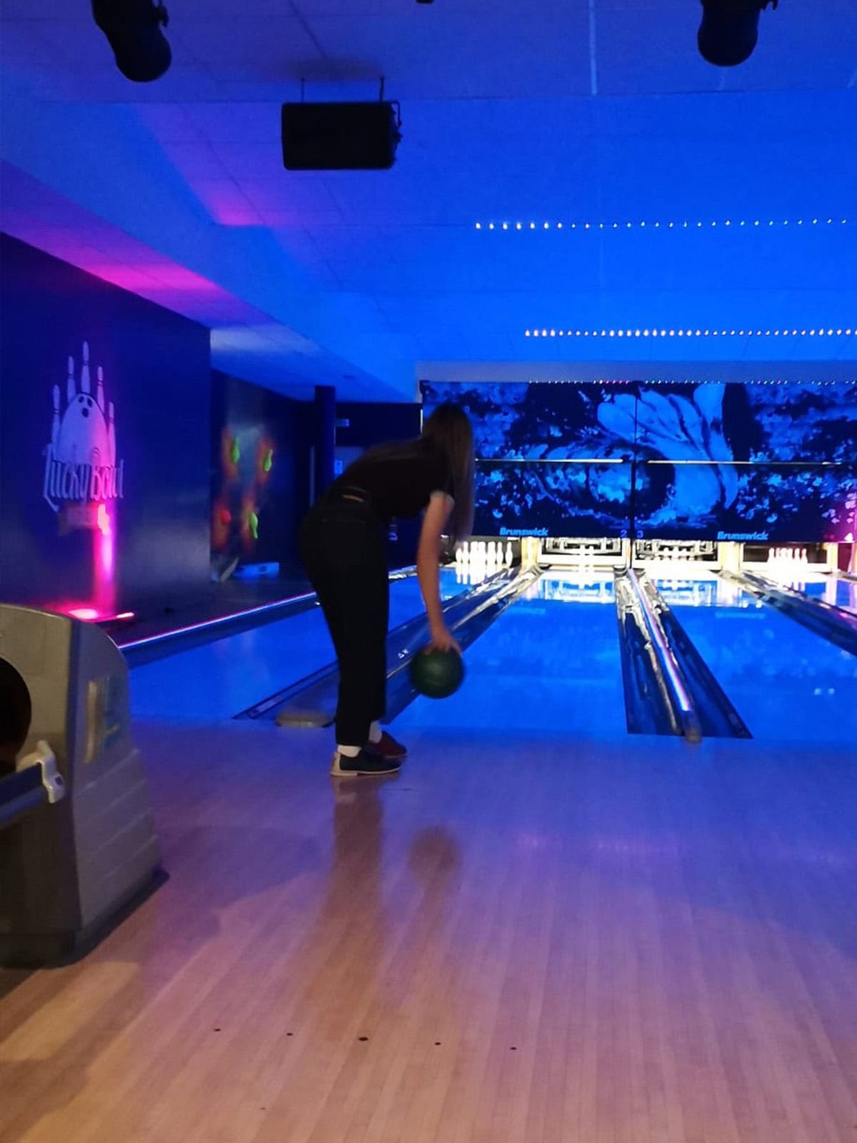 Bowling im LuckyFitness – Weihnachtsfeier 2025 Franzi setzt zum Bowlen an. Sie steht mit der Kugel in der Hand vor der Bowlingbahn
