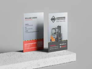 Zwei Visitenkarten für Anders Gabelstapler GmbH stehen auf einem Tisch und zeigen Vorder- und Rückseite. Das Visitenkarten Design ist von hummelt und partner.