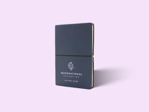 Verschließbares Notizbuch im Corporate Design der International Education UG - mit Logo vorne drauf.