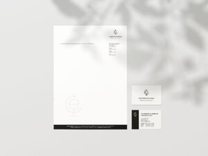 Klassisches Printdesign: Briefbogen und Visitenkarten der Inter-Ed UG liegen auf einem Tisch.