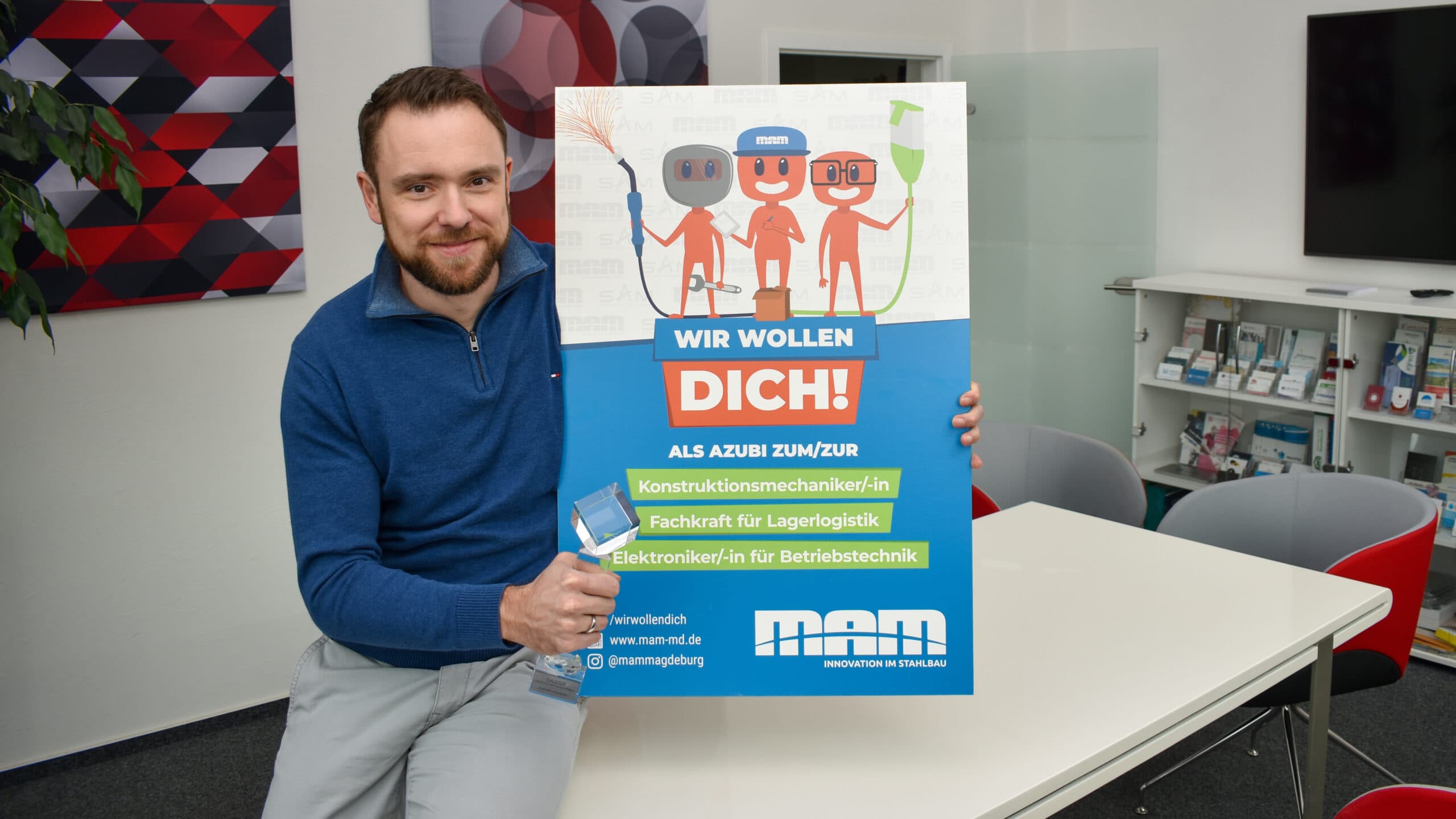 Deutscher Agenturpreis HUPA Jens hält den Deutschen Agenturpreis in der Hand in daneben ein Plakat der ausgezeichneten Azubi-Kampagne für SAM/MAM.