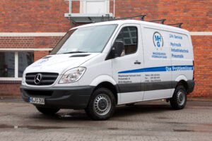 Ein Transporter der Magdeburger Hydraulik GmbH mit einer passenden Beklebung im Corporate Design.